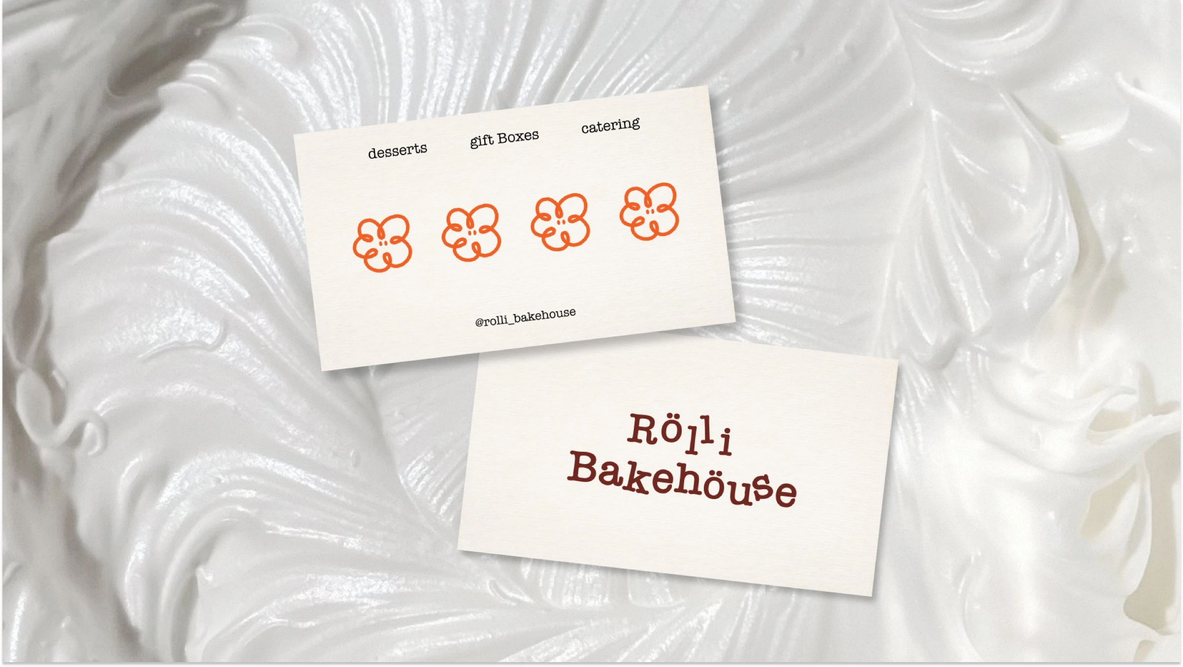 Rolli Bakehouse business cards with the flower logo, laid on whipped cream