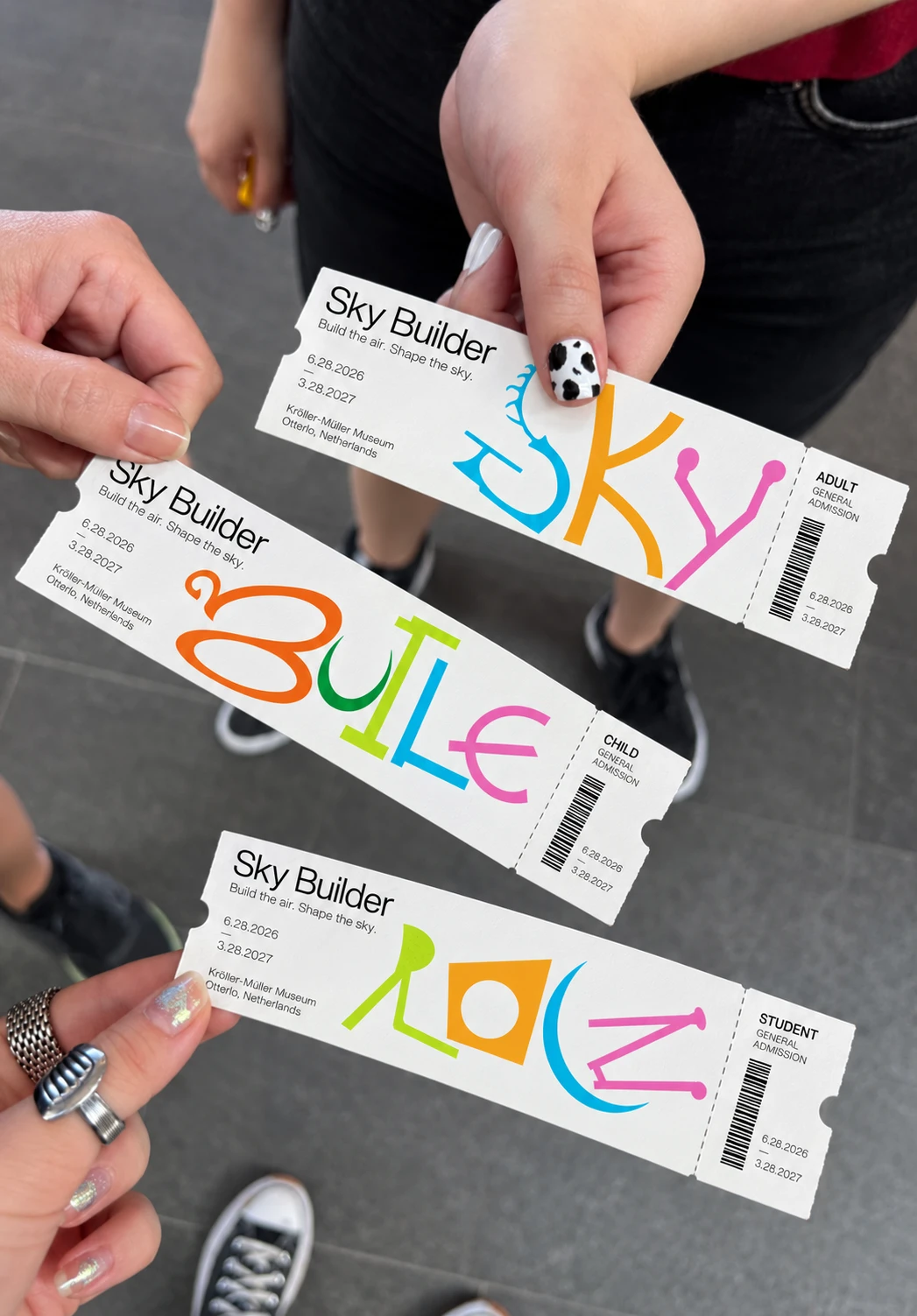 Three hands holding the adult, child and student Sky Builders tickets