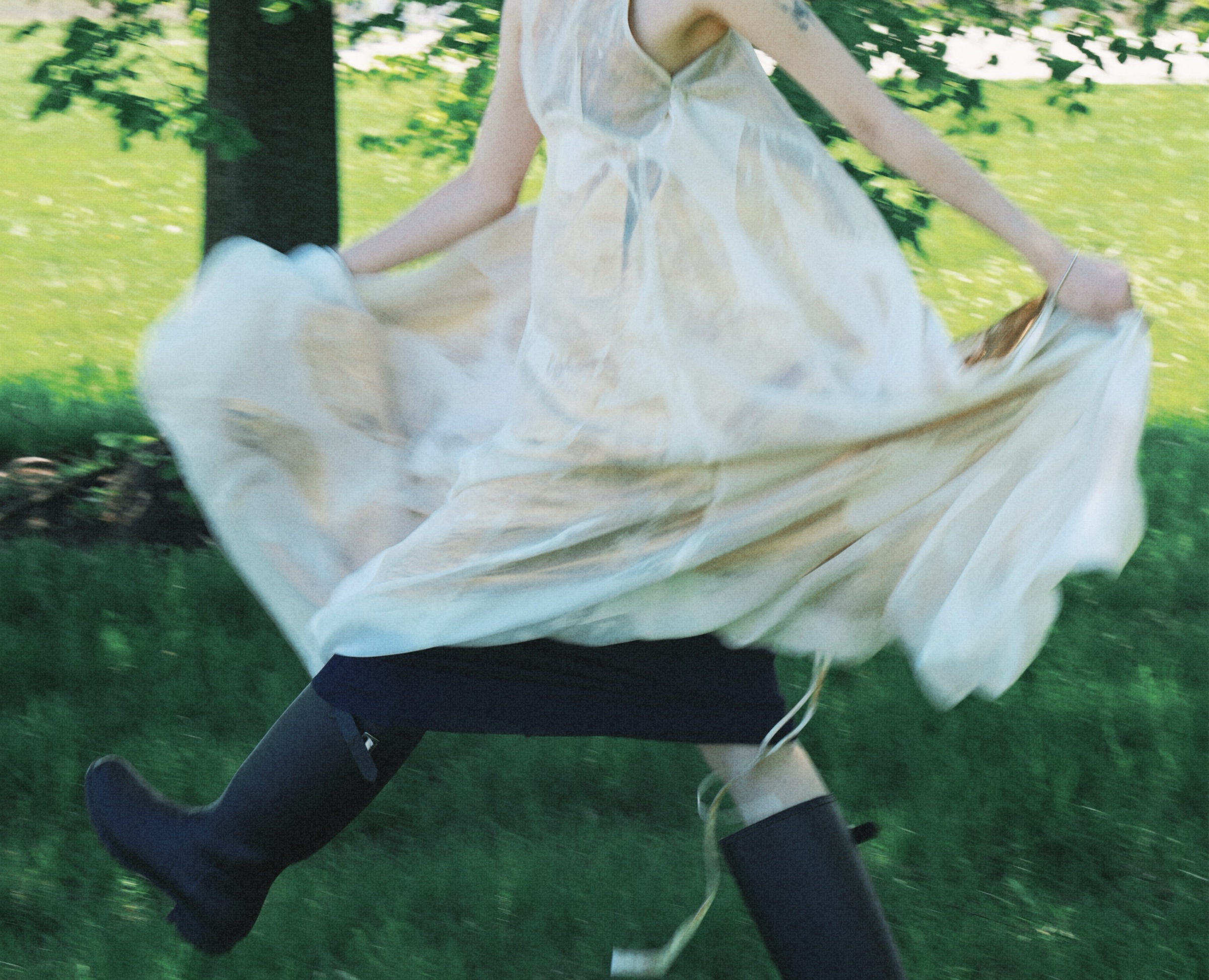 Three models in June Kim's pale draped dresses on the grass by Lake Michigan